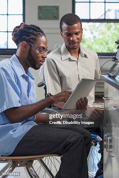 paraplegic student and classmate using digital tablet - disability collection stock pictures, royalty-free photos & images