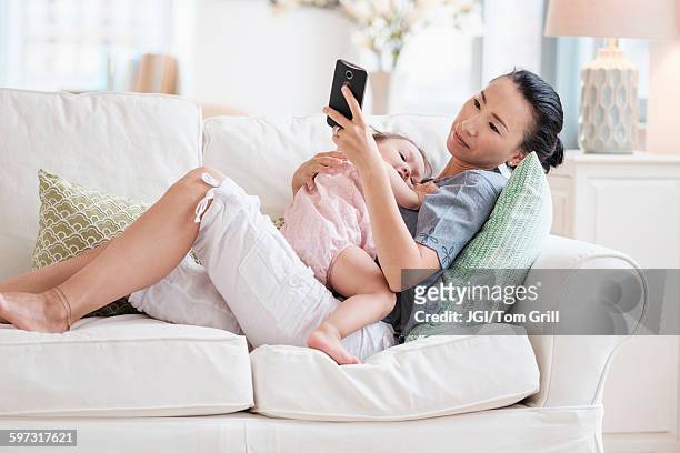 mother and baby daughter using cell phone - receiving text stock pictures, royalty-free photos & images