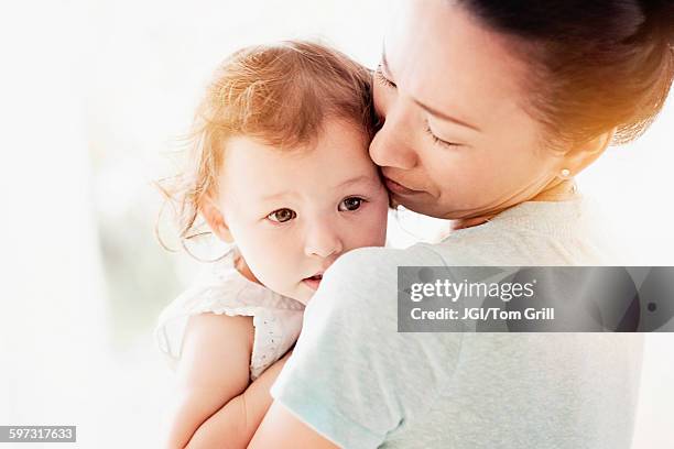 mother holding baby daughter - wange an wange stock-fotos und bilder