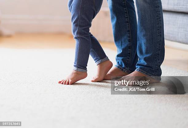 mother and baby daughter with bare feet - girls barefoot in jeans stock-fotos und bilder