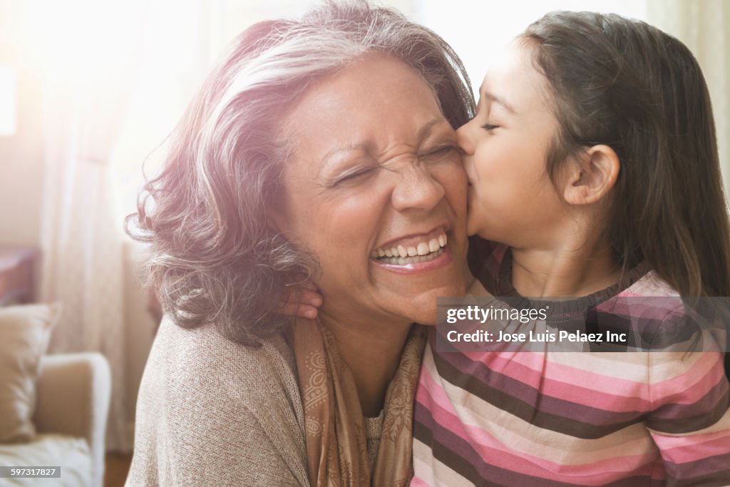 Granddaughter kissing cheek of grandmother