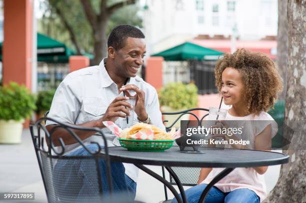 father and daughter eating at outdoor restaurant table - orlando florida family stock pictures, royalty-free photos & images