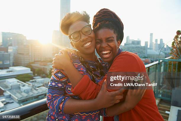 women hugging on city rooftop - ontario canada stock-fotos und bilder