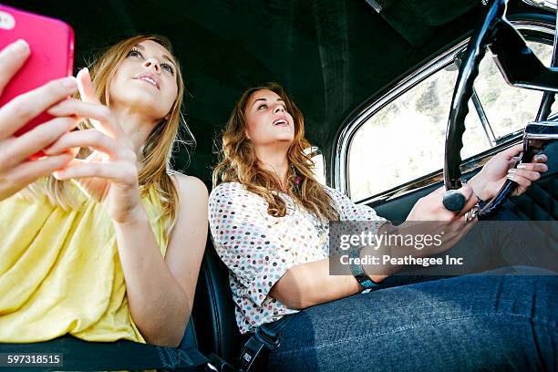 women driving vintage car - mobile phone reading low angle stock pictures, royalty-free photos & images