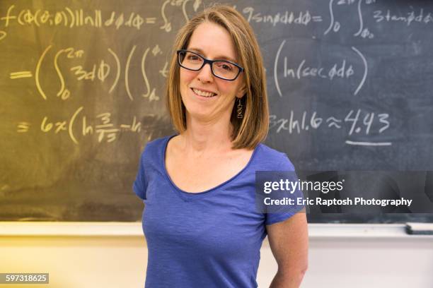 caucasian teacher standing at chalkboard - mathematician stockfoto's en -beelden