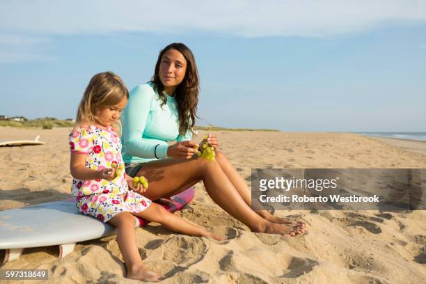mother and daughter eating grapes on beach - advice woman travel traveling stock pictures, royalty-free photos & images