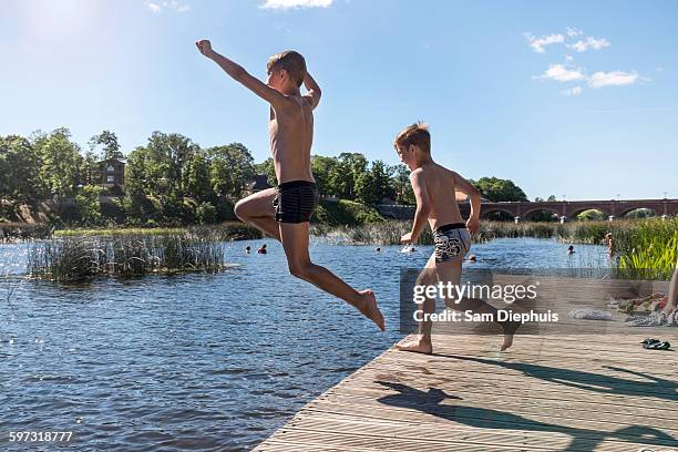 caucasian children jumping into lake - leap of faith activity stock pictures, royalty-free photos & images