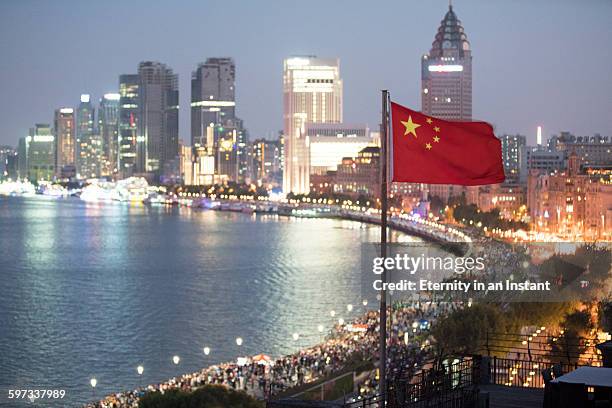 chinese flag waving in front of shanghai cityscape - vlag planten stockfoto's en -beelden