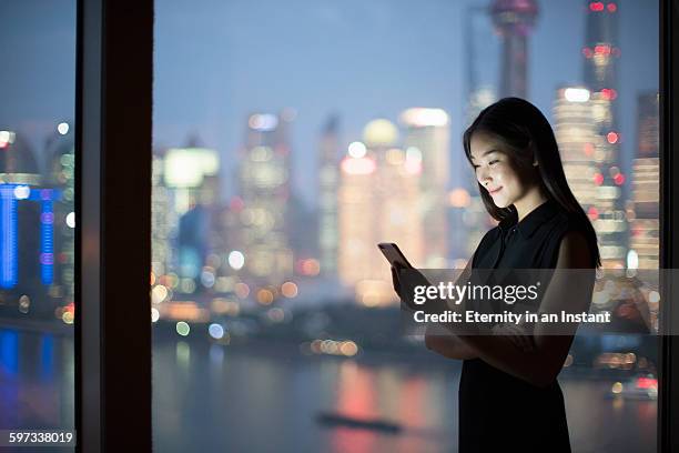 young woman standing in front of a window - frau business glas modern stock-fotos und bilder