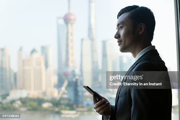 young man looking out of the window. - shanghai calling stock pictures, royalty-free photos & images