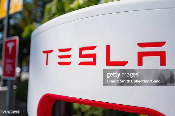 Close up of Tesla logo on a charger at a Supercharger rapid battery charging station for the electric vehicle company Tesla Motors, in the Silicon...