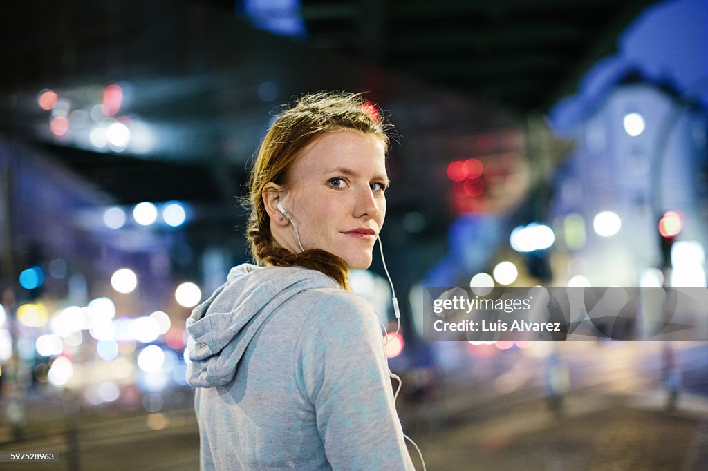 Female runner listening music on city street