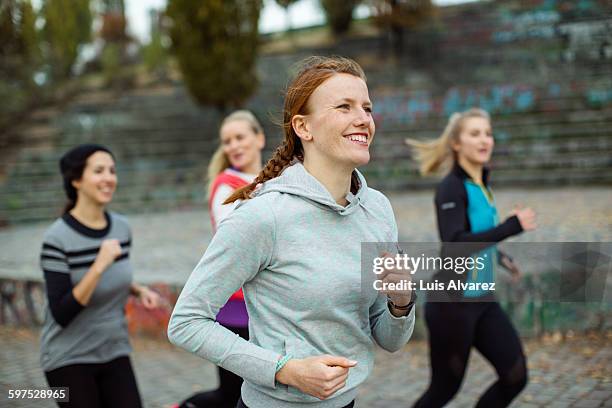 fit woman with friends jogging in park - small group of people stock pictures, royalty-free photos & images