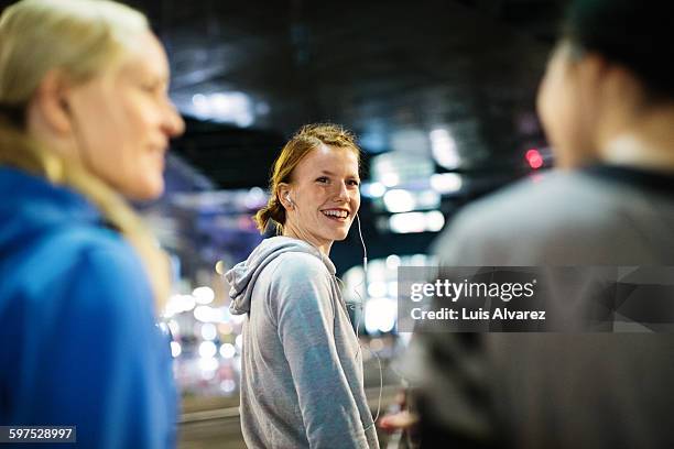 happy female runner looking at friends in city - happy runner stockfoto's en -beelden