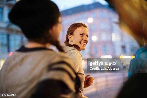 smiling woman with friends jogging on street - cities stock-fotos und bilder