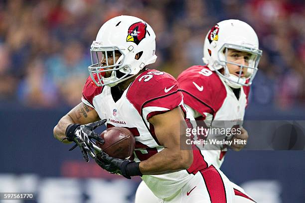Matt Barkley hands off the ball to Elijhaa Penny of the Arizona Cardinals drops back to pass during a preseason game against the Houston Texans at...