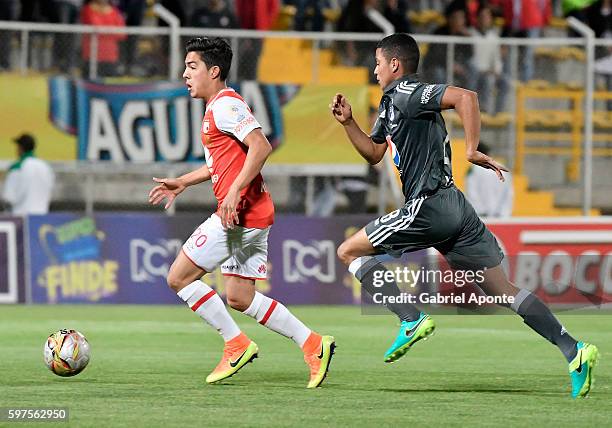 Kevin Salazar of Santa Fe struggles for the ball with Steven Vega of Millonarios during a match between Independiente Santa Fe and Millonarios as...