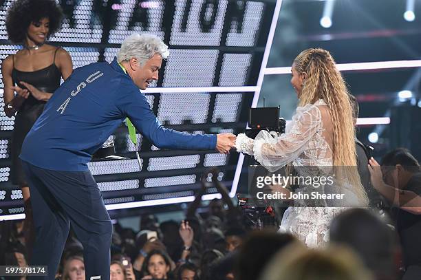 Jimmy Fallon helps Beyonce onto the stage during the 2016 MTV Music Video Awards at Madison Square Gareden on August 28, 2016 in New York City.