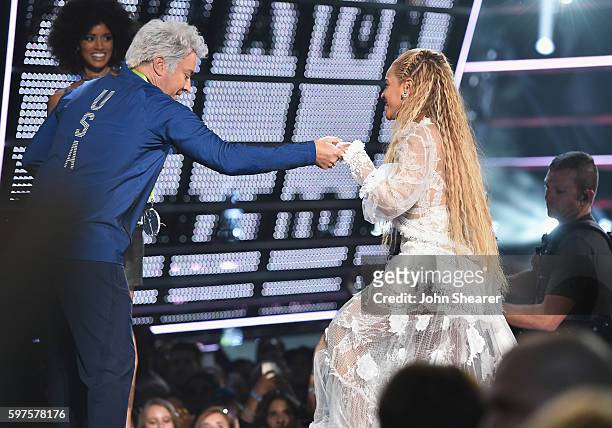 Jimmy Fallon helps Beyonce onto the stage during the 2016 MTV Music Video Awards at Madison Square Gareden on August 28, 2016 in New York City.
