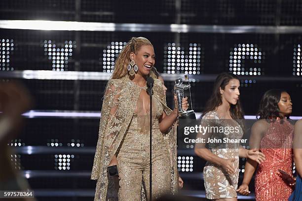 Beyonce accepts an award onstage from Aly Raisman and Simone Biles onstage during the 2016 MTV Music Video Awards at Madison Square Gareden on August...