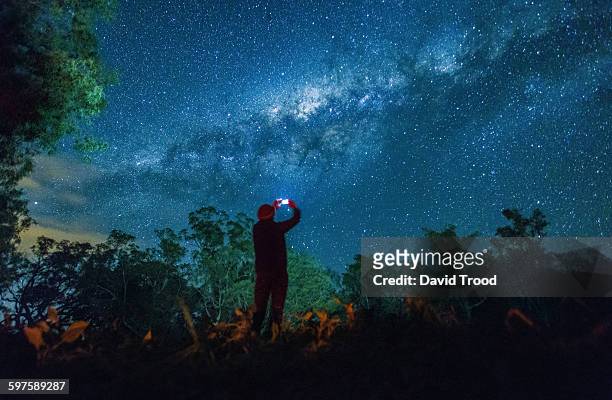 man taking photo of night sky with smart phone - awe imagens e fotografias de stock