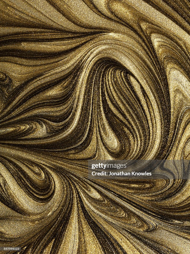 Glitter gold paint marbled swirl patterns