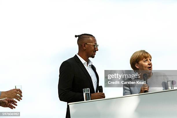 German Chancellor Angela Merkel talks with Jerome Boateng during the annual open-house day at the Chancellery on August 28, 2016 in Berlin, Germany....