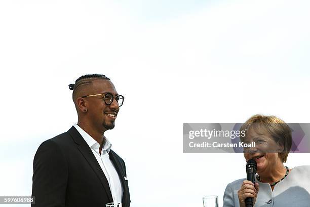 German Chancellor Angela Merkel talks with Jerome Boateng during the annual open-house day at the Chancellery on August 28, 2016 in Berlin, Germany....