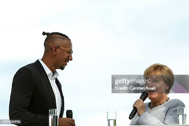 German Chancellor Angela Merkel talks with Jerome Boateng during the annual open-house day at the Chancellery on August 28, 2016 in Berlin, Germany....