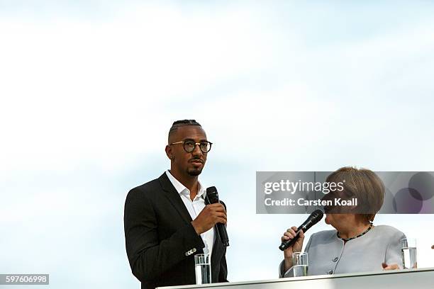 German Chancellor Angela Merkel talks with Jerome Boateng during the annual open-house day at the Chancellery on August 28, 2016 in Berlin, Germany....