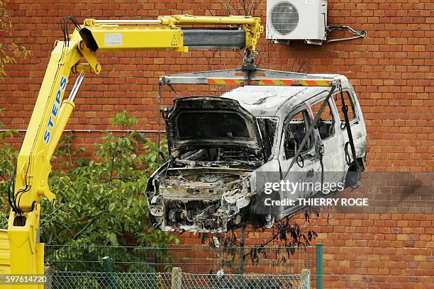 This picture taken on August 29 shows the burnt car used to ram raid the National Institute for Criminalistics and Criminology overnight in...