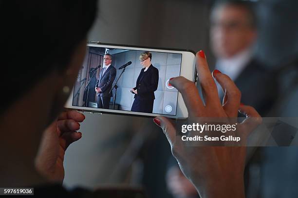 Journalist uses an iPhone to film German Interior Minister Thomas de Maiziere and Tina Kulow, Facebook Corporate Communications Director for...