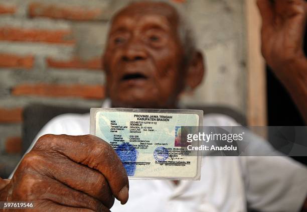 An Indonesian man, named Mbah Gotho, claimed to be 146 years old, is the oldest human in world's history shows his identity card to press members at...