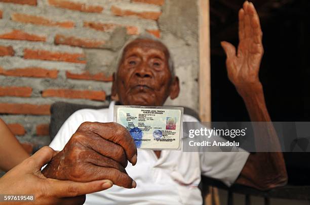 An Indonesian man, named Mbah Gotho, claimed to be 146 years old, is the oldest human in world's history shows his identity card to press members at...