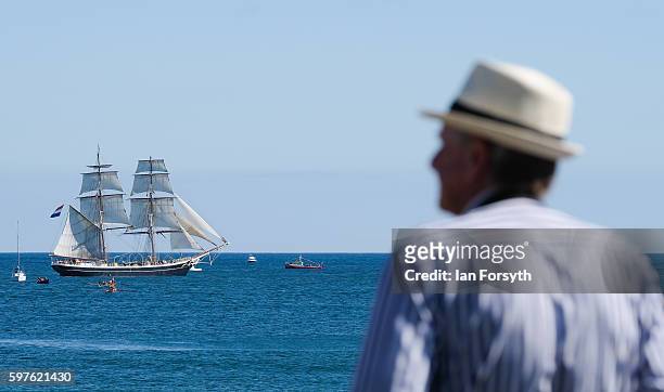 Man stands and watches as the the North Sea Tall Ships Parade of Sail leaves Blyth harbour on August 29, 2016 in Blyth, England. The bustling port...