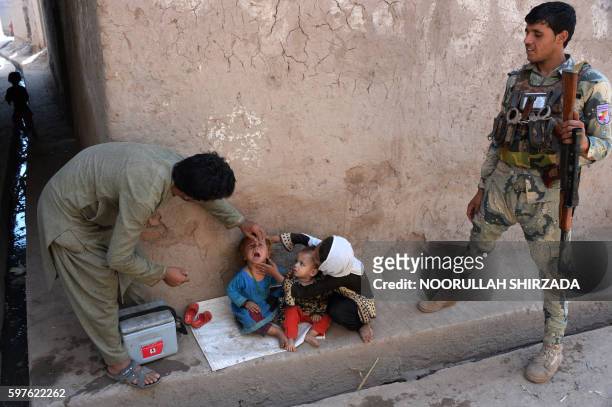 An Afghan health worker administers polio drops to a child during a polio vaccination campaign in the Surkh Rod district of Nangarhar province on...