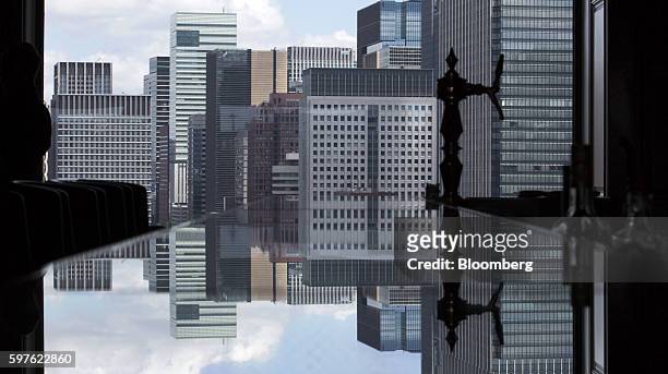 Commercial buildings are reflected on a tabletop in the Imperial Lounge Aqua bar at the Imperial Hotel in Tokyo, Japan, on Friday, Aug. 19, 2016....