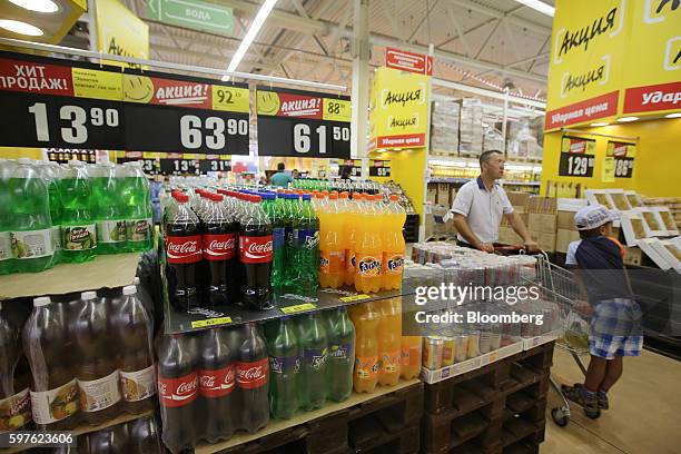 Bottles of Coke, Sprite and Fanta produced by the Coca-Cola Co., sit on pallets inside an Essen hypermarket operated by ZAO Essen Production AG, in...