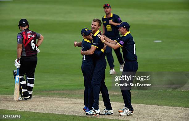 Warwickshire fielders Laurie Evans and Rikki Clarke congratulate bowler Oliver Hannon-Dalby after he had trapped Somerset batsman Jim Allenby lbw...