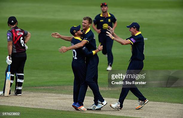 Warwickshire fielders Laurie Evans and Rikki Clarke congratulate bowler Oliver Hannon-Dalby after he had trapped Somerset batsman Jim Allenby lbw...