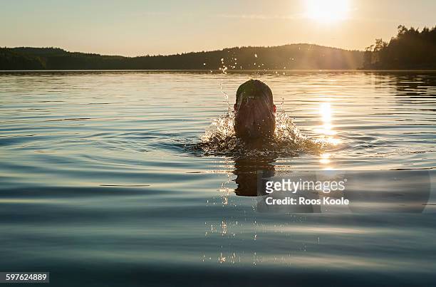 a man refreshes himself with a splash of water - lake finland bildbanksfoton och bilder