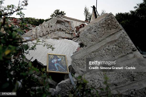 Painting of a dancer lies amongst the ruins of a collapsed buildings in the hamlet of Saletta on August 24, 2016 in Amatrice, Italy. The region in...