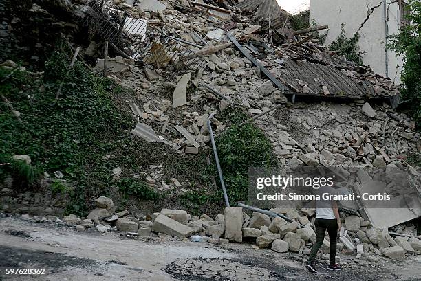Man walks past collapsed buildings in the hamlet of Saletta on August 24, 2016 in Amatrice, Italy. The region in central Italy was struck by a...