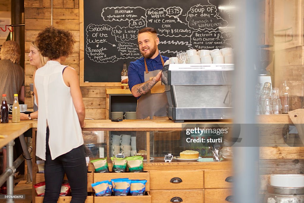 Smiling barista serving customer