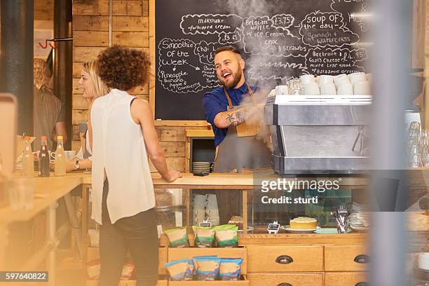 barista sharing a joke with customer - barista stock pictures, royalty-free photos & images