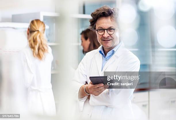 porträt eines männlichen mid adult scientist im labor - arztpraxis stock-fotos und bilder
