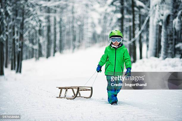 little boy and his sled in winter worest. - tobogganing 個照片及圖片檔