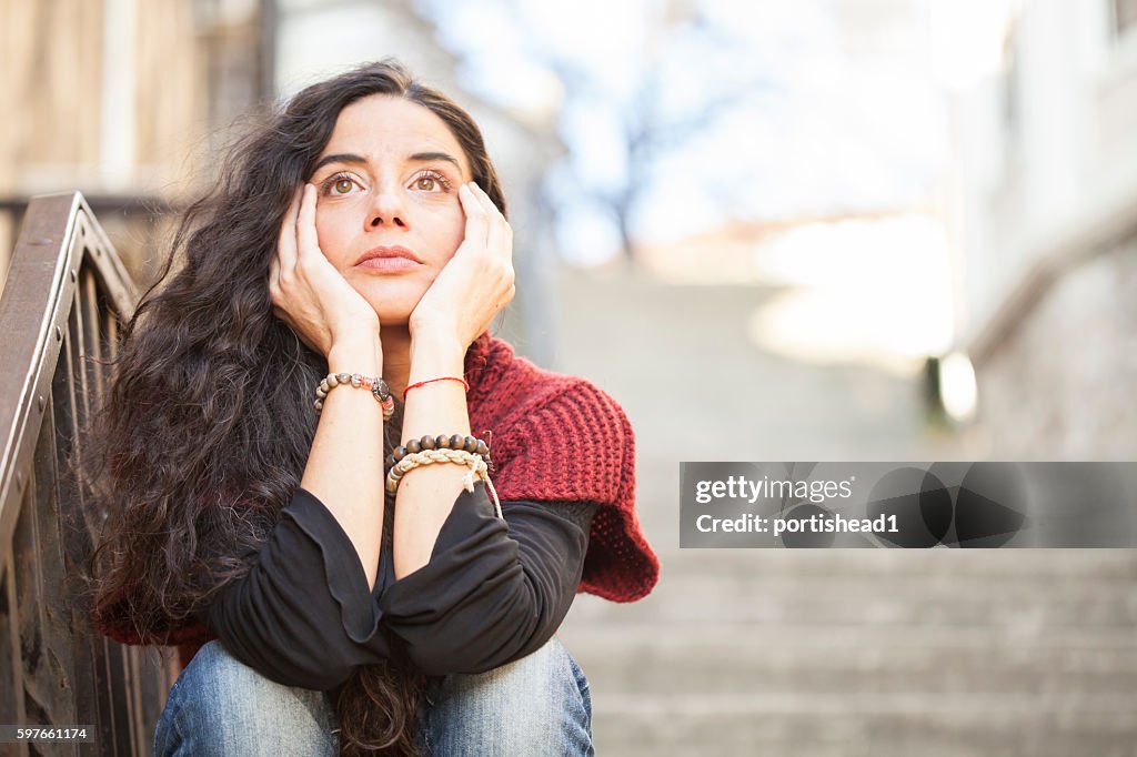 Young woman sitting alone on stairs