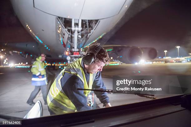 ground crew uncoupling tug a380 aircraft on runway at night - airport crew stock pictures, royalty-free photos & images