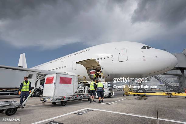 ground crew loading freight onto a380 aircraft - cargo pants stock-fotos und bilder